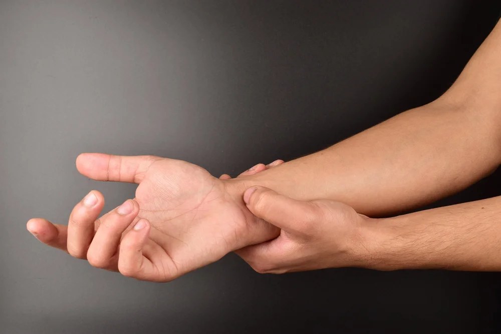 Fingertip pressing the Shenmen point on the inner wrist