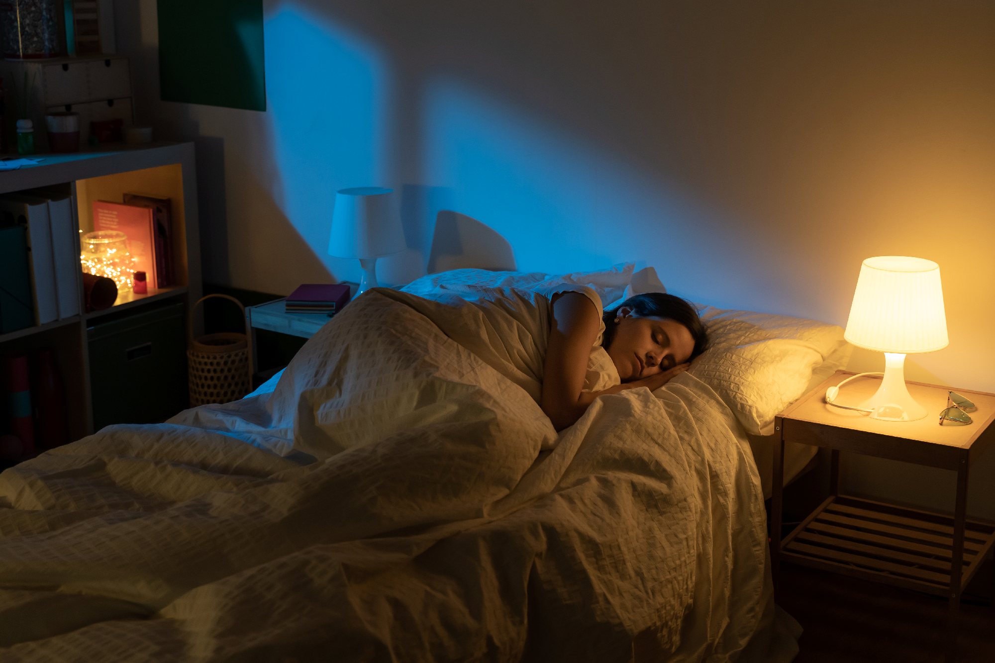 Quiet bedroom prepared for sleep, warm cup on the nightstand