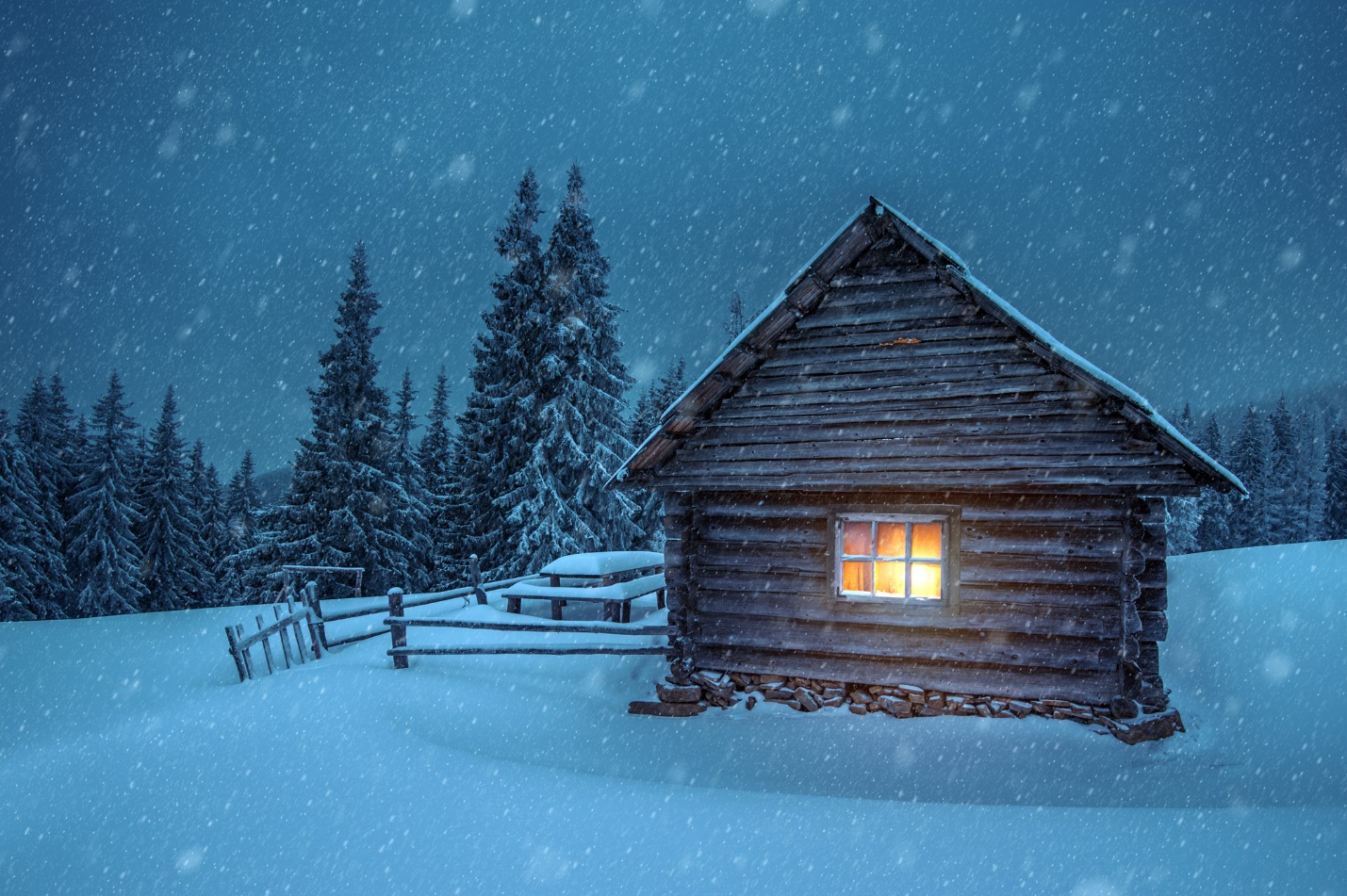 冬日雪景中透出暖光的小屋