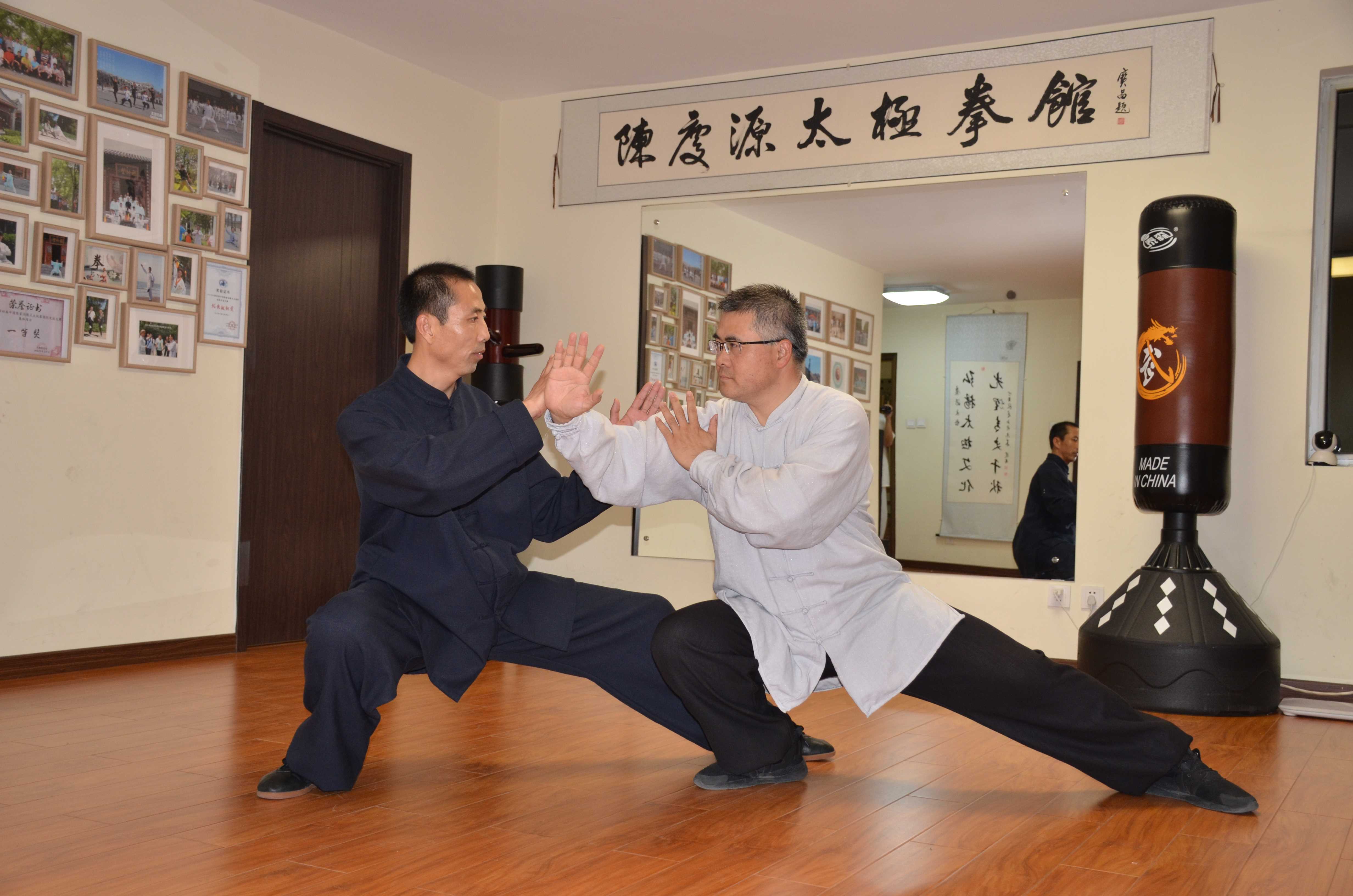 两位练习者在公园里搭手练习太极推手